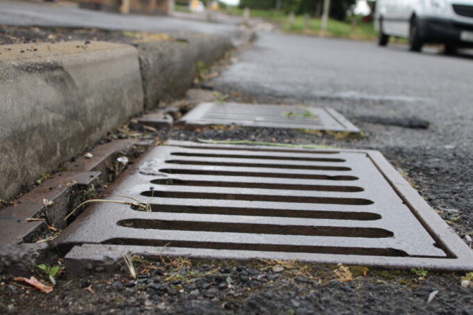 The grate of a catch basin on a street