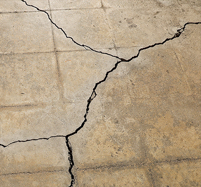 a large crack on a concrete tile floor