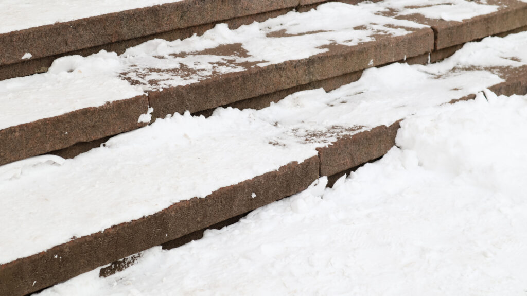 Snow covering three concrete stairs