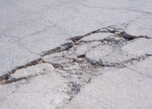 The old badly damaged concrete street background with collapsed and broken crack texture on surface